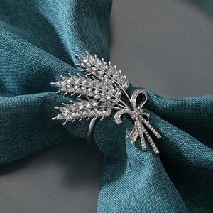 Silver crystal wheat ear bowknot napkin ring on blue textured fabric for table decor