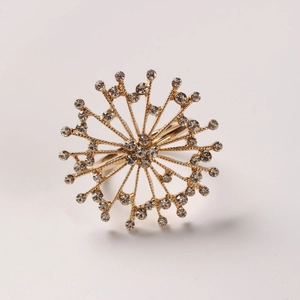 Close-up of gold starburst napkin ring with sparkling crystals for elegant dinner tables