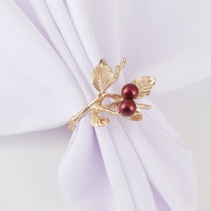Golden branch napkin ring with red berries on a white cloth for Christmas tables