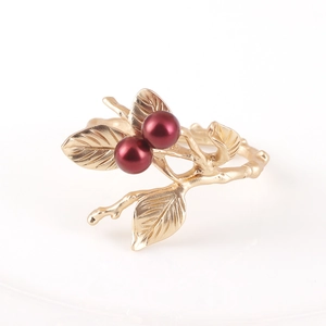 Golden twig napkin ring with red berry details for Christmas table settings