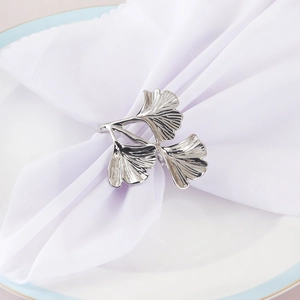Rond de serviette en feuilles de ginkgo argentées sur une assiette pour banquet