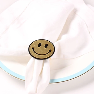 Creative yellow smiley face napkin ring set on a white dinner plate for banquet decor