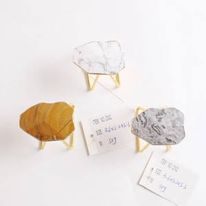 Modern marble napkin rings with golden tripod base for elegant wedding table settings
