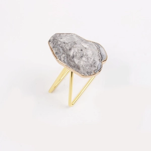 Elegant marble napkin ring with gold trim and tripod metal stand for wedding tables