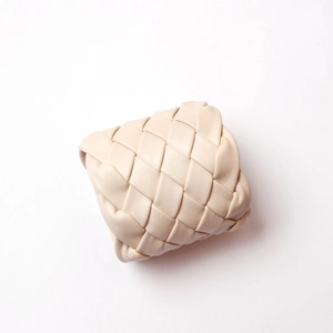 Detail of handcrafted beige leather woven napkin ring with Intrecciato pattern