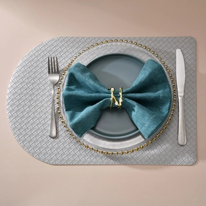 Silver woven placemat with golden pearl napkin ring and dark blue tableware set