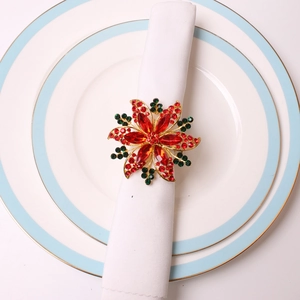 Rond de serviette fleur de Noël avec strass rouges et alliage doré sur serviette blanche