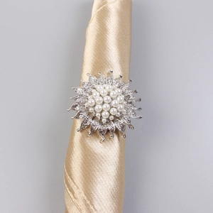 Elegant pearl sunflower napkin ring with silver petals on golden satin fabric