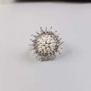 Macro detail of sunflower napkin ring with clustered white pearls and silver petals