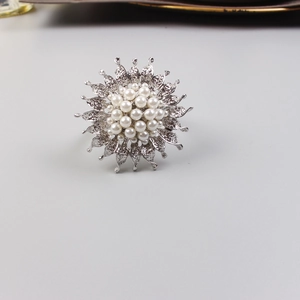 Detailed close-up of sunflower napkin ring with white pearls on a silver metal base
