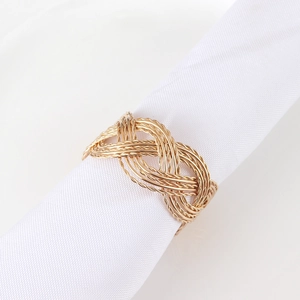 Elegant gold braided metal napkin ring in infinity shape on white fabric