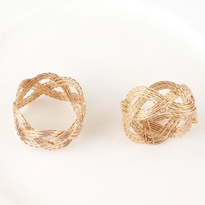 Polished gold metal braided napkin rings with elegant twisted rope texture for table decor
