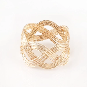 Braided gold metal napkin ring with intricate woven texture for elegant table decor