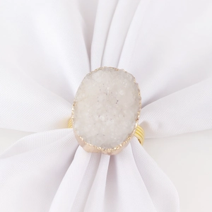 Détail macro du rond de serviette en pierre de druzy blanche avec anneau en fil doré