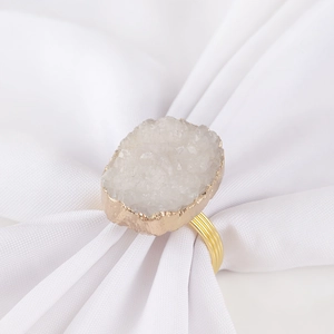 Rond de serviette élégant plaqué or avec cristal blanc sur une serviette blanche