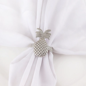 Elegant silver metal pineapple napkin ring with textured finish on white fabric