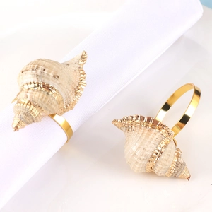 Set of two gold conch napkin rings with metallic finish for ocean-themed table decor