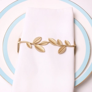 Elegant gold leaf napkin ring with detailed metallic veins on white napkin decoration