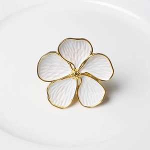 Detailed macro shot of white five-petal flower napkin ring with gold-plated trim