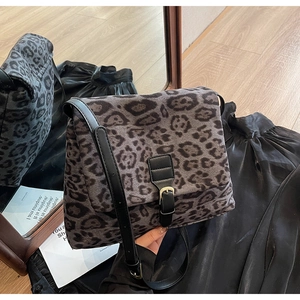 Detail of leopard print crossbody bag with faux fur texture and gold buckle closure