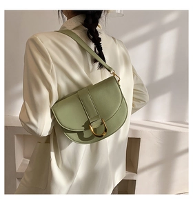 Hellgrüne Satteltasche mit goldener D-Schnalle am Modell mit minimalistischem Licht