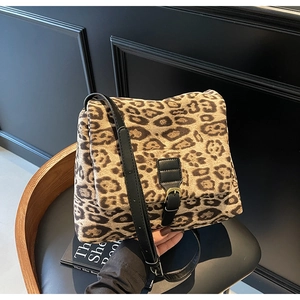 Detail of leopard print faux fur crossbody bag with black leather trim and gold buckle