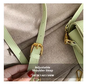 Details einer salbeigrünen Ledertasche mit verstellbarem Riemen und goldener Hardware