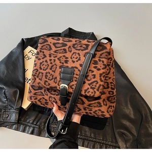 Detail of leopard print crossbody bag with gold buckle and black leather strap