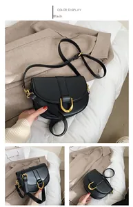 Details einer mattschwarzen Satteltasche mit goldenem Hufeisenverschluss und Gurt