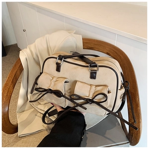 Gros plan du sac bandoulière rétro beige avec nœuds en cuir marron et texture élégante