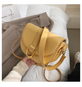 Detailaufnahme der gelben Satteltasche aus PU-Leder mit goldener D-Ring-Schnalle und Gurt