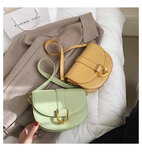 Details von minzgrünen und senfgelben Satteltaschen mit goldenen Hufeisenschnallen
