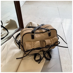 Vue détaillée d'un sac Boston kaki avec des accents de nœud marron et double fermeture