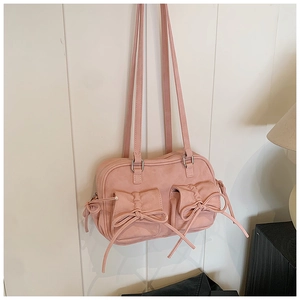 Détail du sac à bandoulière rose clair mat avec nœuds et boucles en métal argenté