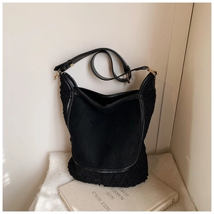 Detail of black bucket bag with soft sherpa trim and adjustable faux leather shoulder strap