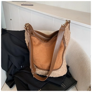 Detail of contrast stitch bucket bag showing brown matte leather and teddy fleece texture