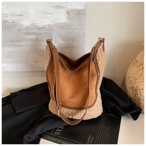 Detail of contrast shearling bucket bag featuring caramel suede textures and gold hardware