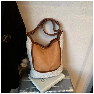 Detail of contrast bucket bag with white faux fur and brown suede on vintage luggage