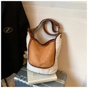 Detail view of contrast stitching and plush shearling texture on bucket bag