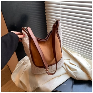 Detail of contrast bucket bag featuring brown suede and white faux shearling textures