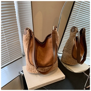 Detail of hobo bag featuring brown leather trim and beige faux shearling textures