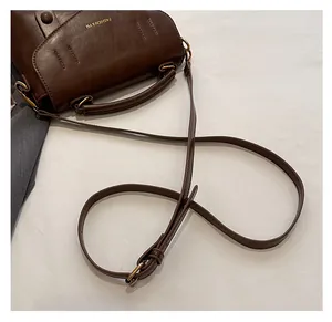 Nahaufnahme der braunen Vintage-Leder-Schultertasche mit verstellbarem Riemen und Logo