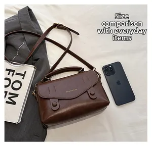 Detaillierter Größenvergleich der dunkelbraunen Ledertasche mit Smartphone und Zubehör