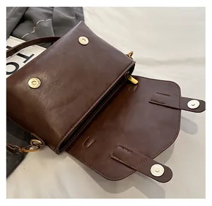 Details einer braunen Lederhandtasche mit Doppelmagnetverschluss und Innenfächern
