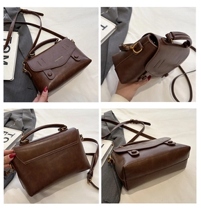 Detailansicht der Vintage-Handtasche aus braunem PU-Leder mit Goldlogo und Schultergurt