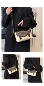 Detail der cremefarbenen Tasche mit brauner Klappe, Golddruck und verstellbarem Gurt