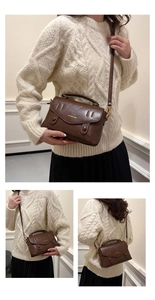 Detailansicht einer dunkelbraunen Ledertasche mit Goldschrift und verstellbarem Schultergurt