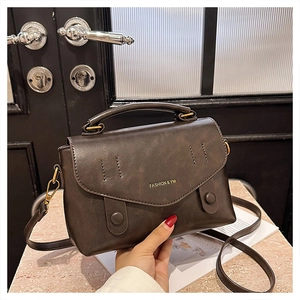 Detail of vintage dark brown faux leather handbag with adjustable shoulder strap and logo