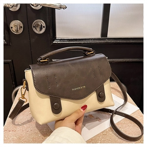 Detail of two-tone faux leather crossbody bag with top handle and FASHION logo
