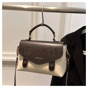 Detail showing vintage two-tone brown and white crossbody bag with FASHION & YM logo